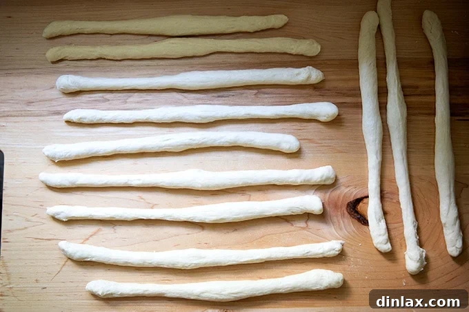 Pillowy Soft Pretzels Made Simple 15 Twelve logs of pretzel dough, each about 12 inches long, resting on the counter.
