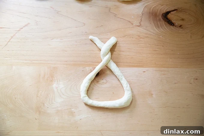 Pillowy Soft Pretzels Made Simple 18 A coil of dough partway twisted into a pretzel shape.