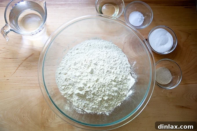 Pillowy Soft Pretzels Made Simple 3 Ingredients to make soft pretzels displayed on a countertop, including flour, yeast, sugar, salt, water, and oil.