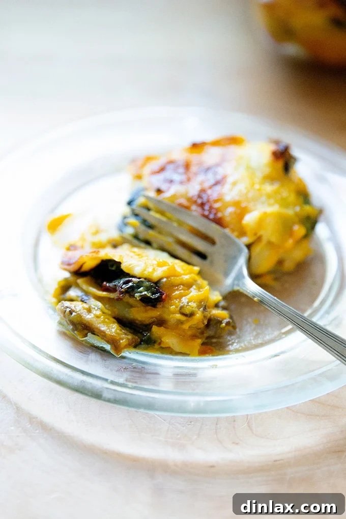 Effortless Butternut Squash Lasagna with Hearty Greens and Mushrooms 2 A delectable slice of butternut squash lasagna featuring vibrant greens and earthy mushrooms, perfectly baked and ready to serve.