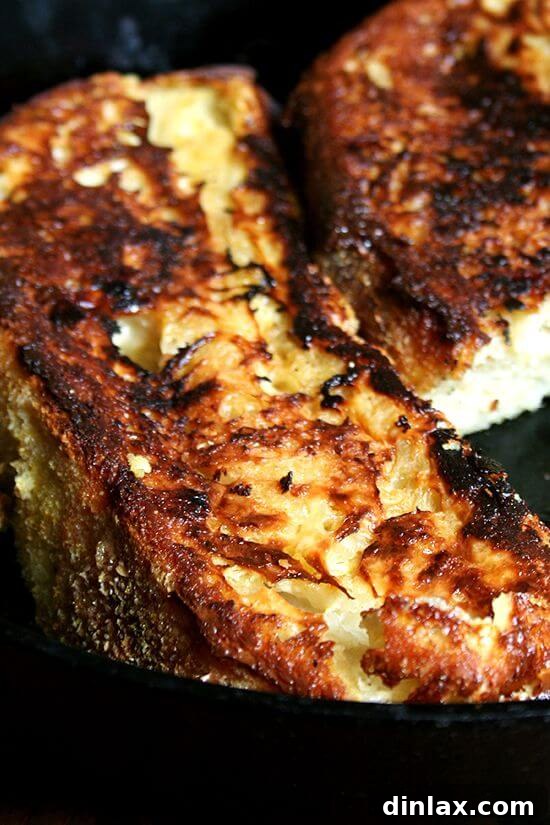 Golden-brown baked French toast slices, caramelized on the outside and perfectly fluffy inside, topped with a dusting of powdered sugar. A hint of lemon zest adds an unexpected, delightful aroma.