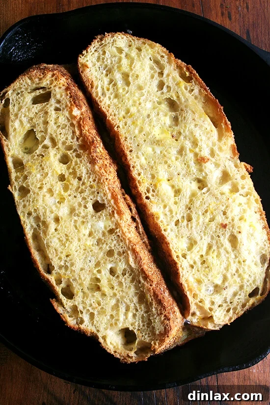 Perfectly baked French toast, fresh out of the oven, showing its beautifully caramelized skillet side and puffed, golden-brown top.