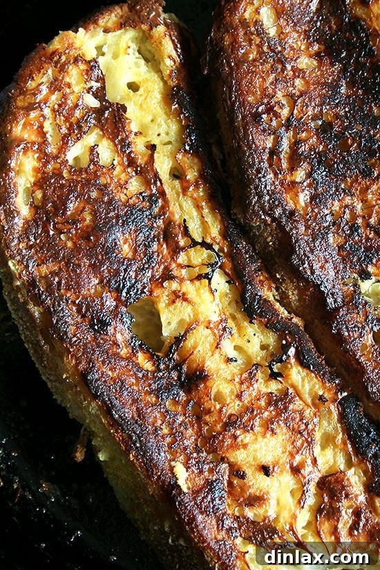A close-up shot of the finished baked French toast, beautifully golden, with a hint of lemon zest, ready to be enjoyed with a drizzle of maple syrup.