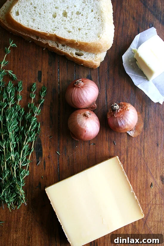 Ingredients laid out for a grilled cheese sandwich, including bread, cheese, shallots, butter, and thyme.