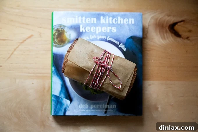 The Smitten Kitchen Keepers cookbook alongside a beautifully wrapped loaf of pound cake, perfect for a thoughtful gift.