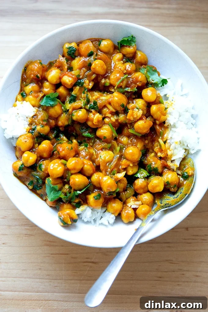 A vibrant bowl of one-pot curried Thai chickpeas served alongside fluffy white rice, garnished with fresh cilantro.