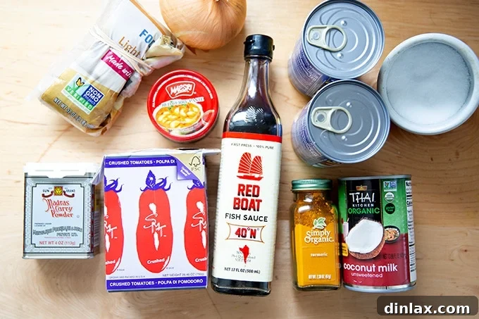 All the essential ingredients neatly laid out for preparing the curried Thai chickpeas, including canned goods, fresh aromatics, and spices.