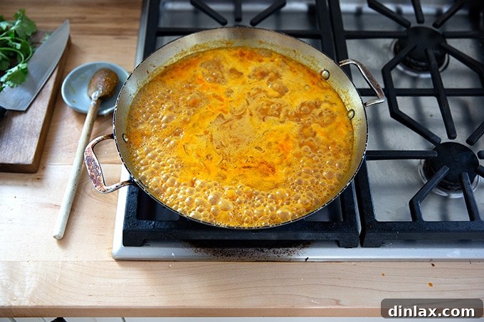 Freshly cooked curried Thai chickpeas resting in the skillet, exhibiting a rich, thick sauce and plump chickpeas, ready for the final touches.