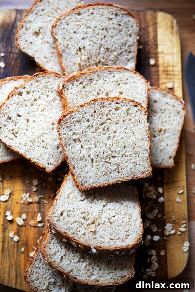 Close-up of a board showcasing multiple slices of wholesome no-knead maple oat bread.