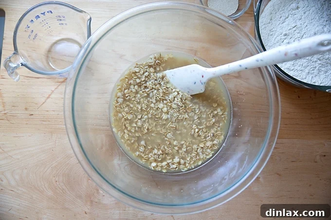 A bowl containing oats, maple syrup, and salt soaking in boiling water.