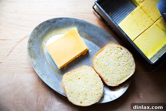 Flour Bakery's Golden Eggwich 9 A halved brioche bun on a sizzle pan aside an egg slice topped with cheese.