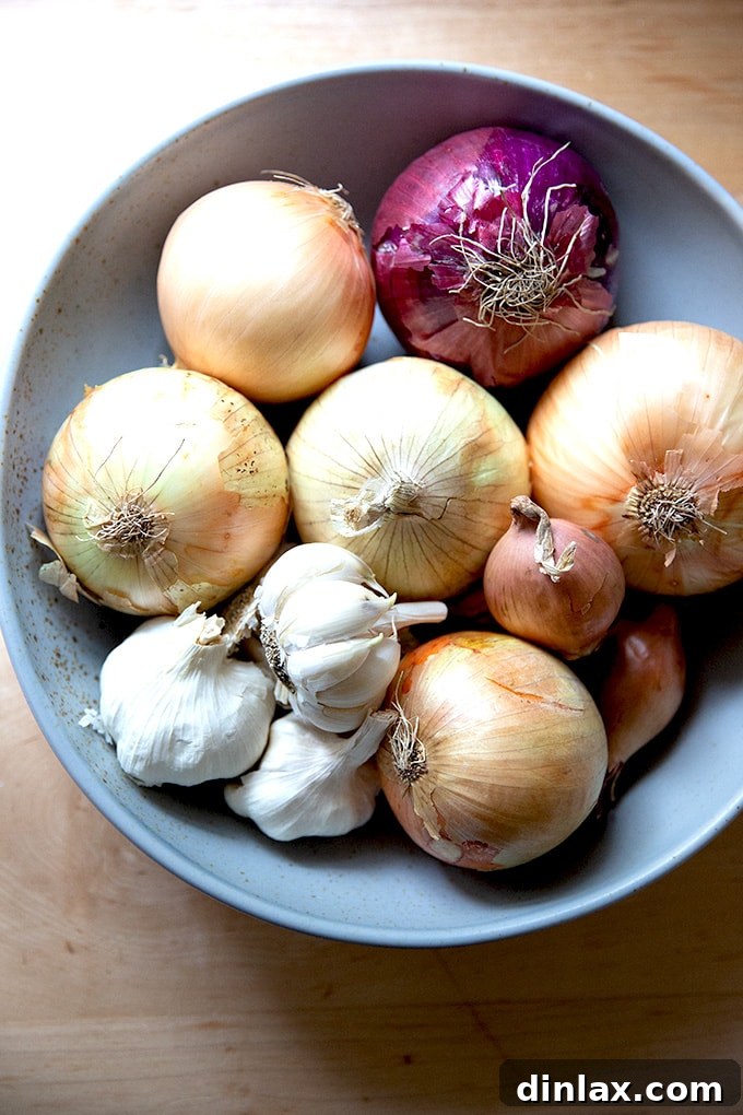 15 Perfect Mothers Day Gifts 10 A rustic, handcrafted ceramic bowl from Masienda, filled with fresh onions and garlic, showcasing its utility and beauty.