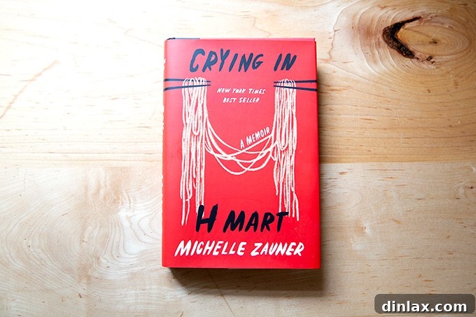 15 Perfect Mothers Day Gifts 4 The cover of 'Crying in H Mart, a memoir' by Michelle Zauner, resting on a countertop.