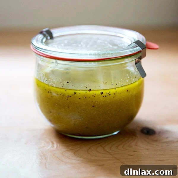 A jar of homemade Greek salad dressing on a countertop, ready to be enjoyed.