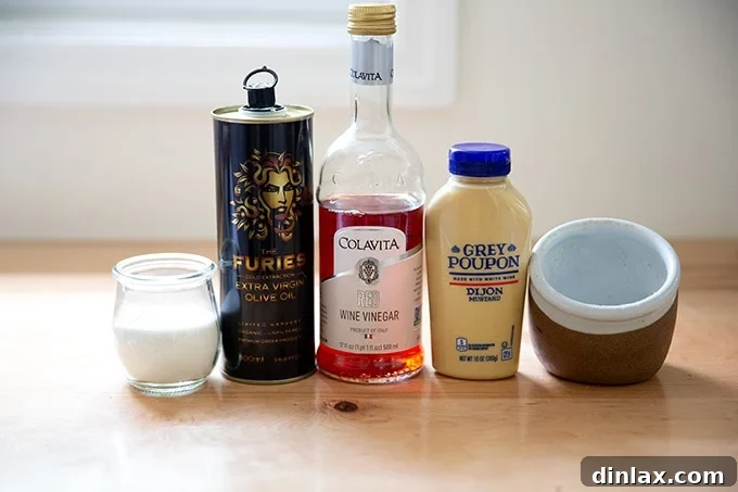 All the fresh ingredients required to make Greek salad dressing are neatly arranged on a clean countertop.