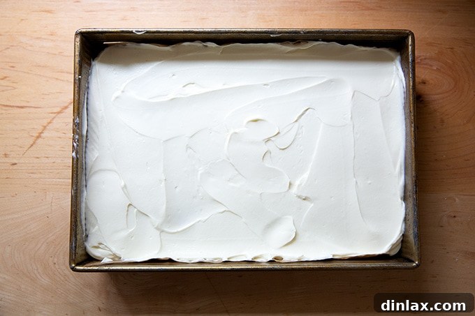 Effortless Star-Spangled Sheet Cake 12 A fully frosted sheet cake, ready for the berry flag decoration, showing the smooth, inviting texture of the cream cheese frosting.