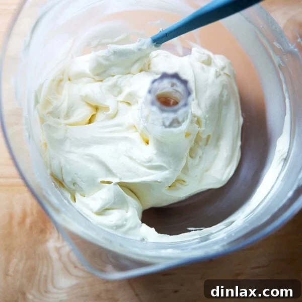 Beaten whipped cream - cream cheese frosting in a stand mixer.