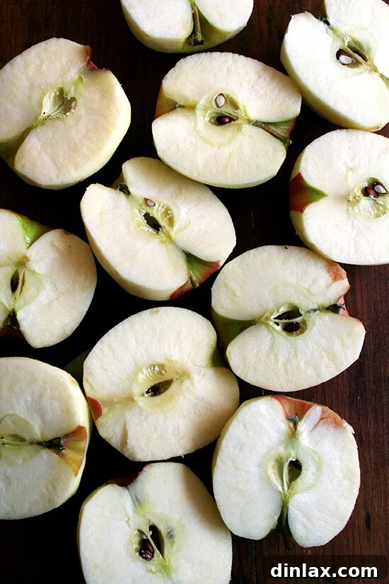 Halved apples, meticulously prepared for elegant slicing and arrangement. Fresh apples, peeled, cored, and halved, perfectly prepared for slicing and fanning into a beautiful French apple tart.