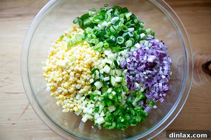 A large bowl filled with colorful bean salad ingredients, ready to be tossed together.