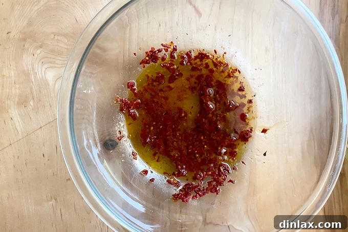 A bowl filled with a freshly whisked sun-dried tomato dressing, showcasing its rich red hue and inviting texture.