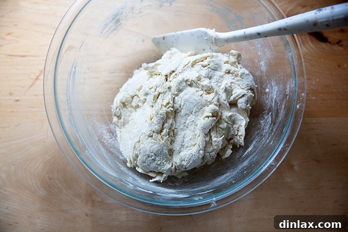 A bowl of shaggy, freshly mixed pretzel roll dough.