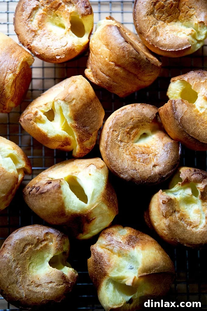 Popovers briefly cooling on a wire rack after being removed from the tin.