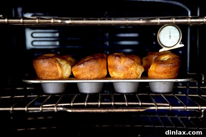 A tray of dramatically risen popovers baking in the oven.