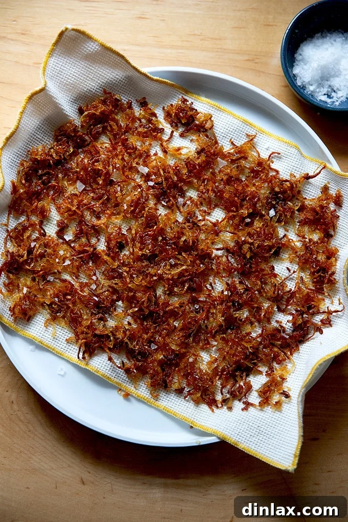 Golden Roasted Green Beans with Sweet Shallot Glaze 12 A plate lined with a cloth towel and crispy fried shallots on top.