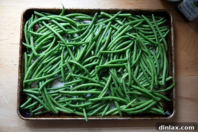 Golden Roasted Green Beans with Sweet Shallot Glaze 15 A sheet pan filled with green beans tossed wit olive oil and kosher salt.