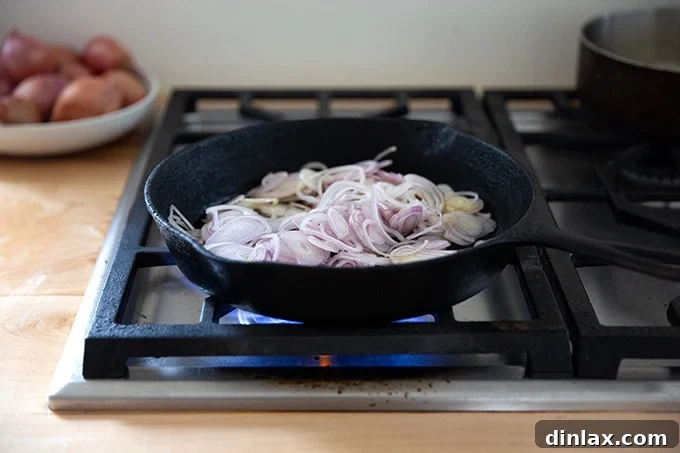 Golden Roasted Green Beans with Sweet Shallot Glaze 8 Shallots in a cast iron skillet on the stovetop.