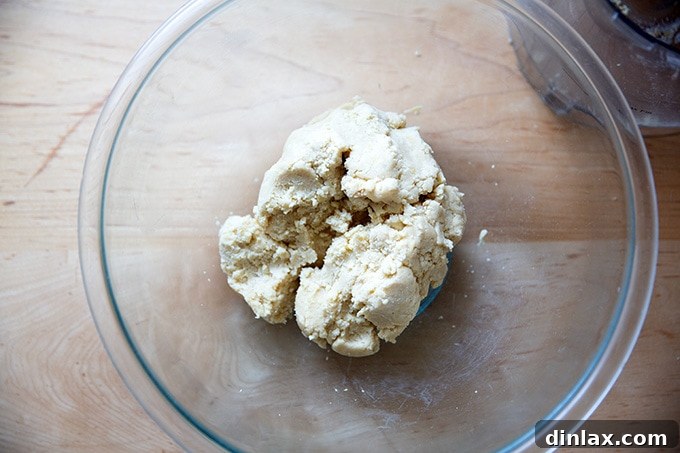 A bowl filled with the pale, uniform lemon-almond snowball cookie dough, ready for portioning.