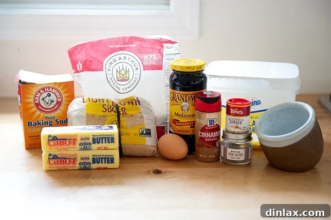 Perfectly Imperfect Gingerbread Cookie Bars 3 A collection of ingredients laid out, including flour, sugars, molasses, butter, an egg, and various spices, ready for making gingerbread cookie bars.