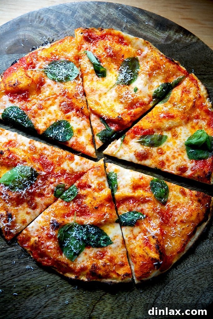 A perfectly baked, cut gluten-free Margherita pizza on a wooden cutting board, showcasing its thin and crispy crust.