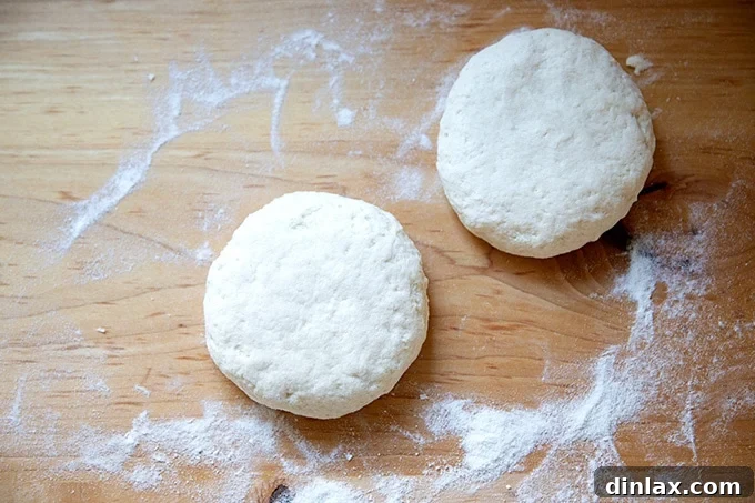 Two neatly balled rounds of gluten-free pizza dough on a countertop.