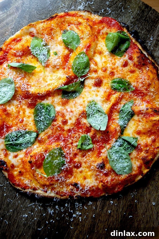 A vibrant, freshly baked gluten-free Margherita pizza, showcasing its beautiful crust and toppings, on a cutting board.