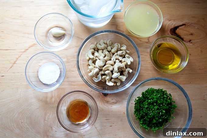 All the fresh ingredients laid out for making vegan ranch dressing, including raw cashews, lemon, garlic, chives, and olive oil.
