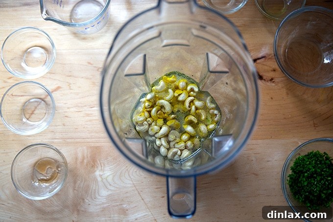 The initial ingredients for vegan ranch dressing, including cashews, lemon juice, garlic, and water, inside a high-speed Vitamix blender.