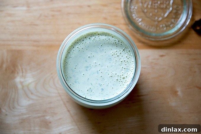 A glass jar filled with the freshly made vegan ranch dressing, ready to be placed in the refrigerator for chilling.