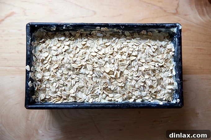 Irish brown bread batter in the loaf pan, sprinkled with oats and ready to bake.