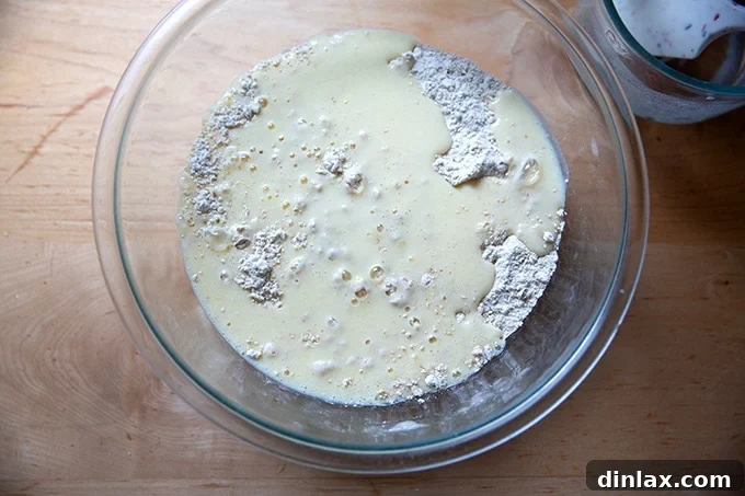 The wet ingredients being added to the dry ingredients for Irish brown bread, starting the mixing process.
