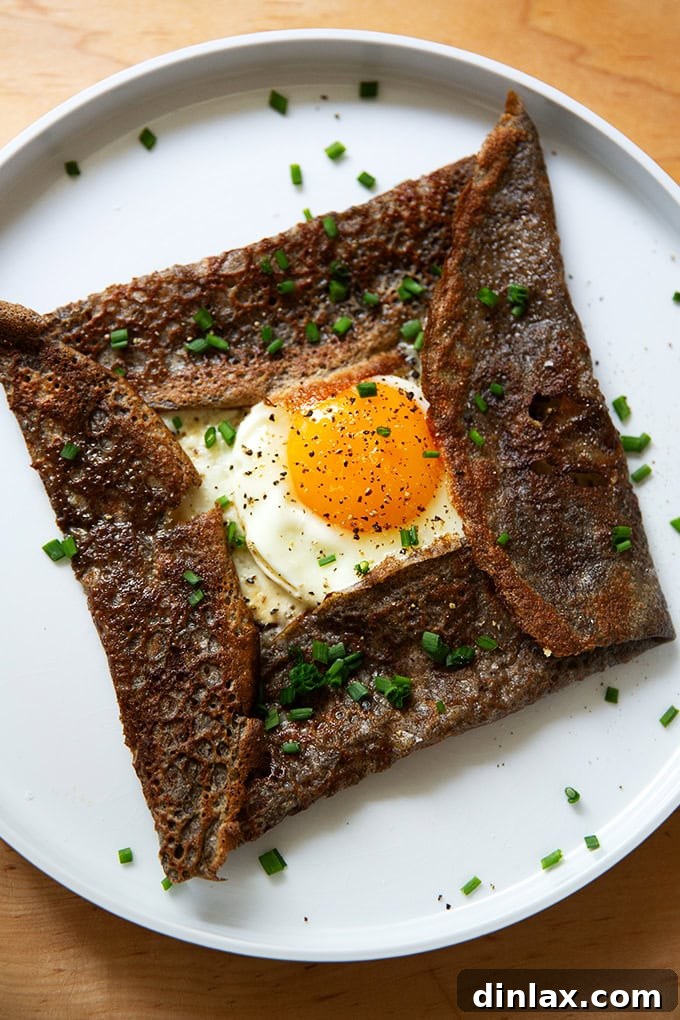Light and Delicate Gluten Free Buckwheat Crepes 2 A plate topped with an egg-and-gruyere filled buckwheat crepe, garnished with fresh chives.