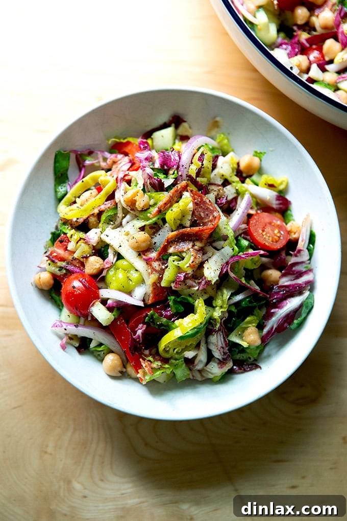 A close-up view of a vibrant bowl of classic chopped salad, showcasing the fresh ingredients beautifully coated in Italian dressing.