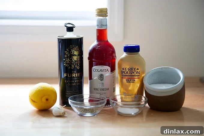 A selection of fresh ingredients to make Italian dressing, including olive oil, vinegar, lemon, and herbs, neatly arranged on a countertop.