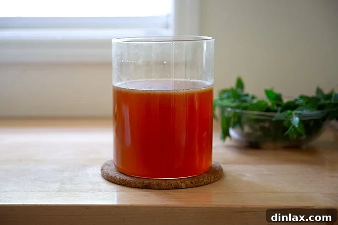 A large glass vessel filled with homemade iced tea, showing the quantity and inviting amber color.