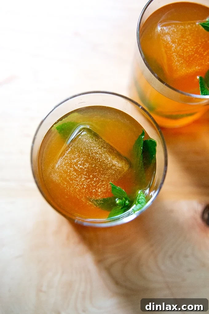 Two glasses of iced tea, each featuring a large, slow-melting ice cube for enhanced refreshment.