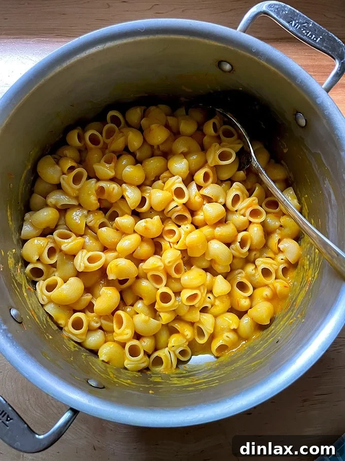 A steaming pot of perfectly cooked pasta, generously coated with the bright and creamy yellow tomato sauce, creating a comforting and delicious meal.