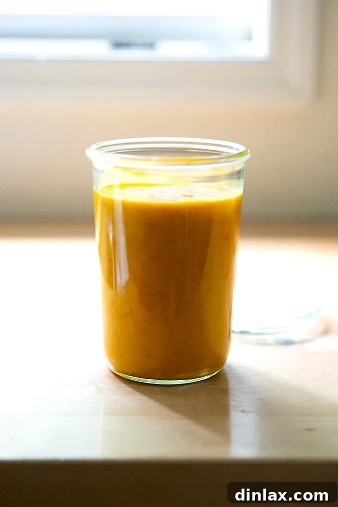 A clear glass jar filled with the rich, golden roasted yellow tomato sauce, ready for storage or gifting, symbolizing homemade freshness and culinary delight.