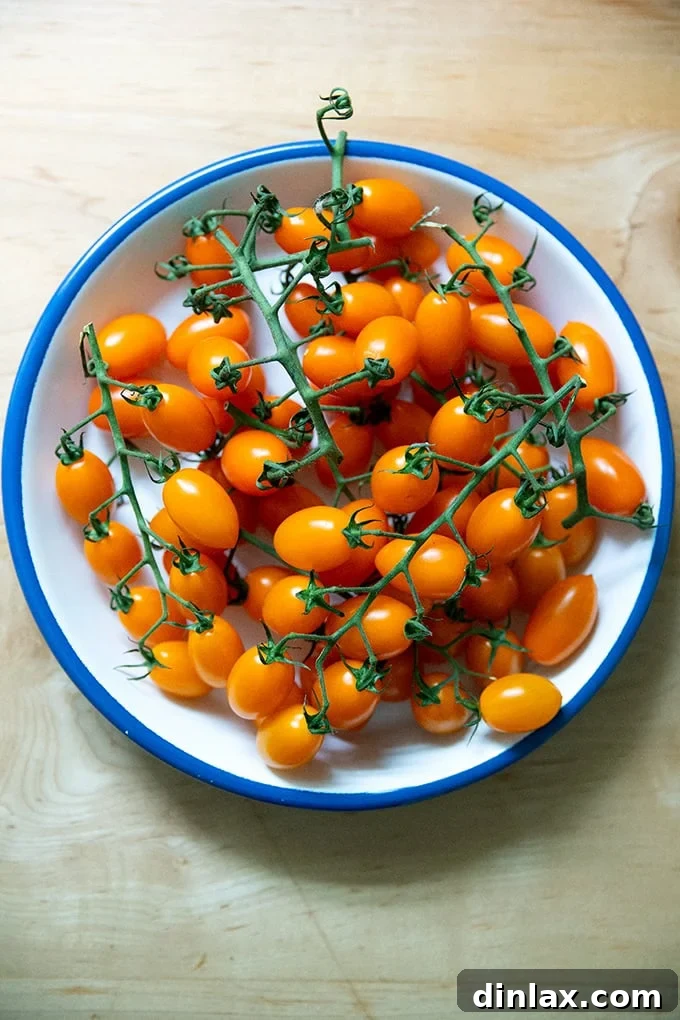 A vibrant plate of plump, ripe yellow cherry tomatoes still on the vine, showcasing their natural beauty and freshness.