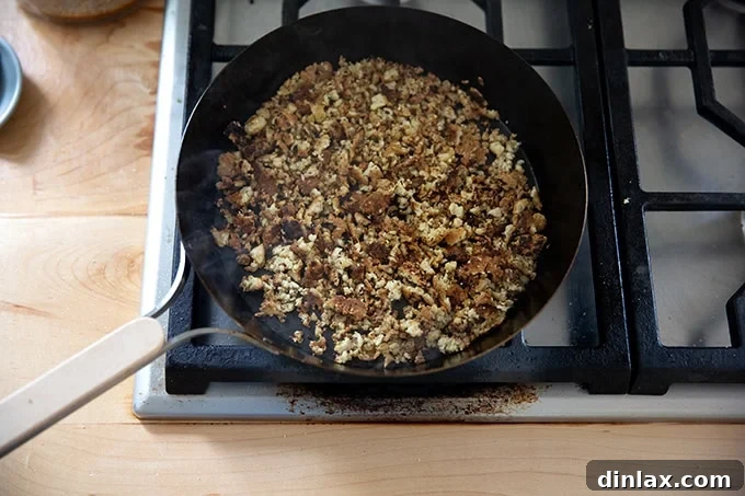 A skillet filled with uniformly browned and crispy tofu crumbles, indicating thorough cooking and perfect texture.