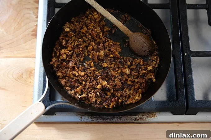Finished miso-lime tofu crumbles resting in the skillet on the stovetop, perfectly coated and ready to be served.